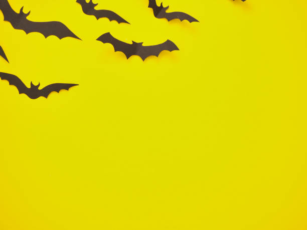 istock halloween decorations concept. Black bats on yellow background. 1157157223