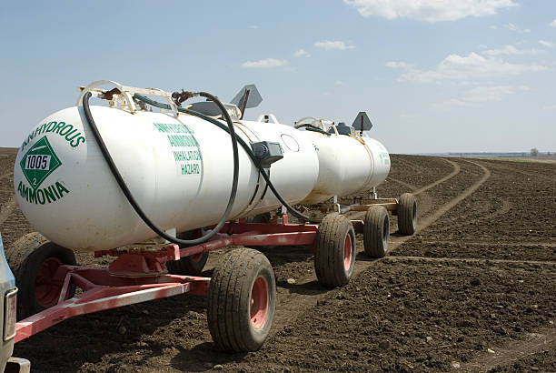 Anhydrous Ammonia Anhydrous Ammonia tanks in newly planted wheat field ammonia fertilizer stock pictures, royalty-free photos & images