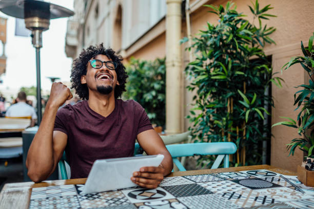 istock Afro American man using tablet in coffee shop 1157165614