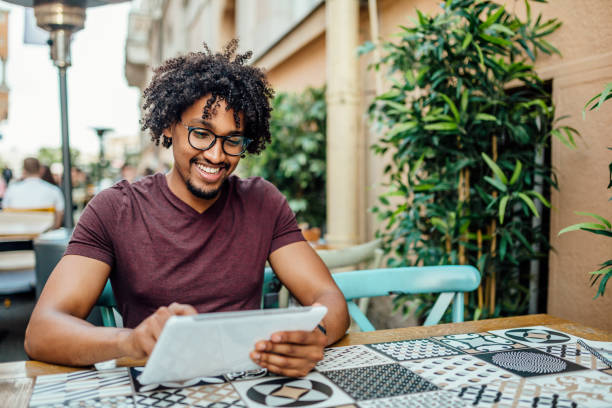 istock Afro American man using tablet in coffee shop 1157165946
