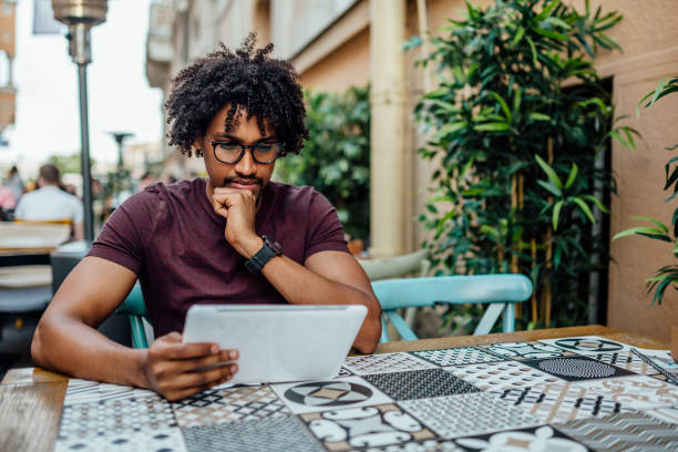 istock Afro American man using tablet in coffee shop 1157166139