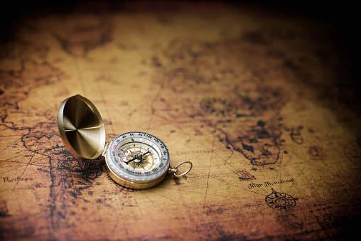 Vintage compass and old navigation map.