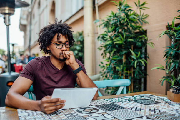 istock Afro American man using tablet in coffee shop 1157166203