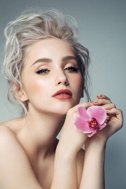 beautiful blond caucasian young woman with flower in hair isolated on white
