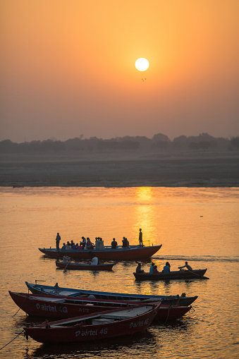 Pilgrims on boat floating on the waters of sacred river Ganges early morning. According to legends, the city was founded by God Shiva about 5000 years ago.