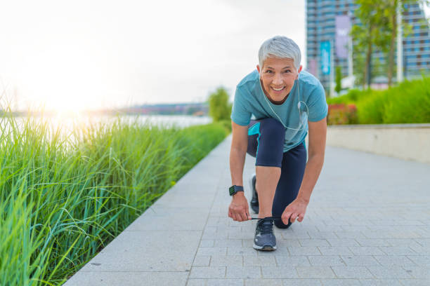 istock Senior runner tying her shoelaces 1157173522