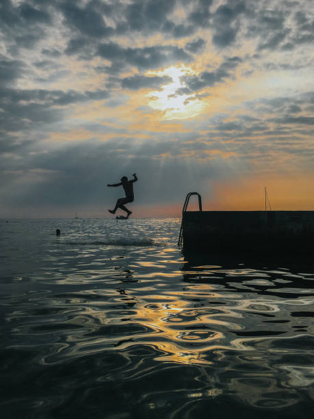istock Boy jumping into the sea 1157173545