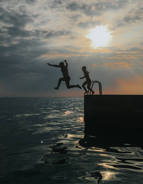 Boys jumping into the sea