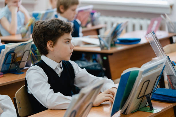 colegial durante la lección - niño en edad escolar fotografías e imágenes de stock