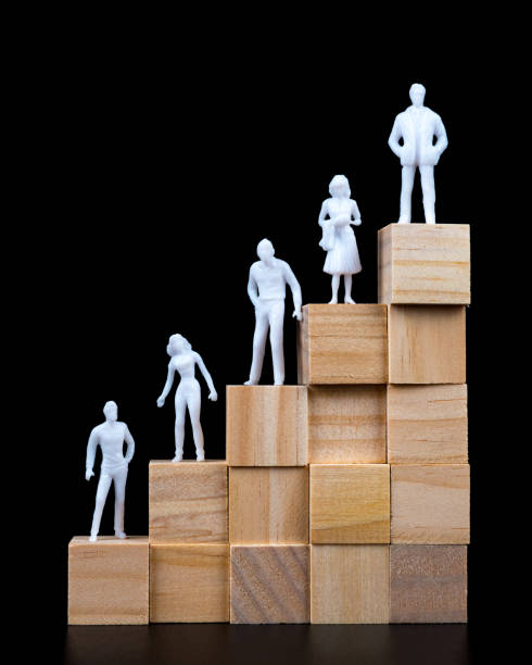 istock White figures of businessmen on a wooden cube pyramid. 1157175123