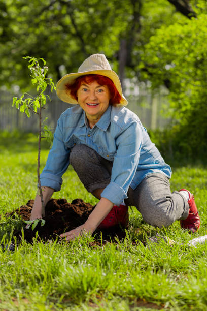 istock Red-haired retired woman feeling happy after planting tree 1157180805