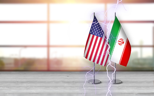 3D USA and iranian flags with metallic pole, standing together on a white wooden desk in front of sunny window background. With large copy space you can write your own titles effectively. Also you can use this compositon as square in social media channels like instagram etc.