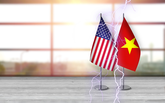 3D USA and vietnamese flags with metallic pole, standing together on a white wooden desk in front of sunny window background. With large copy space you can write your own titles effectively. Also you can use this compositon as square in social media channels like instagram etc.