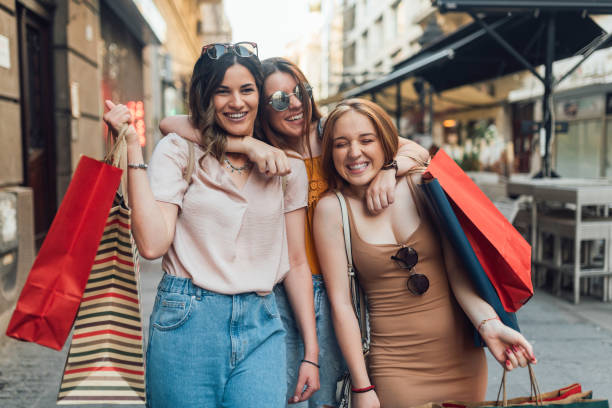 Girls with shopping bags hugging