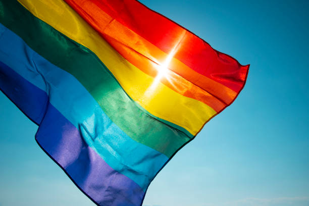 rainbow flag waving on the blue sky - gay pride flag fotos imagens e fotografias de stock