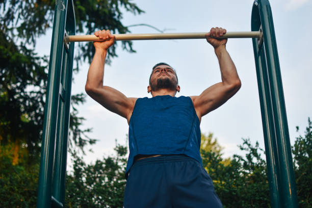 istock Young man exercising on horizontal bar outdoors 1157189280