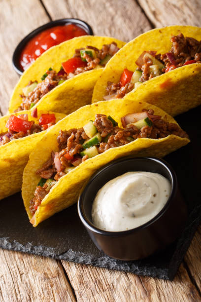 istock Mexican tacos stuffed with minced beef and vegetables close-up. vertical 1157189459