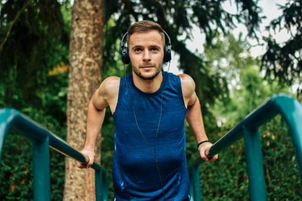 istock Young man exercising on horizontal bar outdoors 1157189480