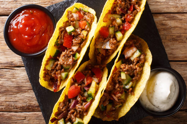 istock Authentic tacos with minced beef, cheese and vegetables are served with sauces close-up. horizontal top view 1157189609