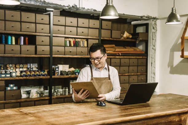istock Smiling manager reading clipboard at table in shop 1157189703
