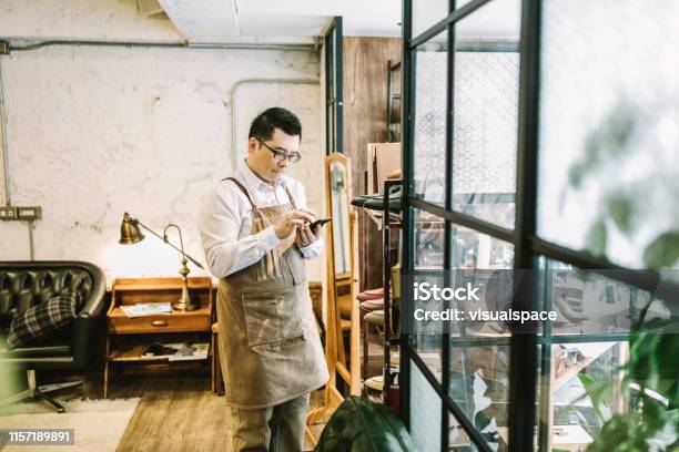 Owner Answering Call While Standing By Window Stock Photo - Download Image Now - Small Business, Owner, Asian and Indian Ethnicities