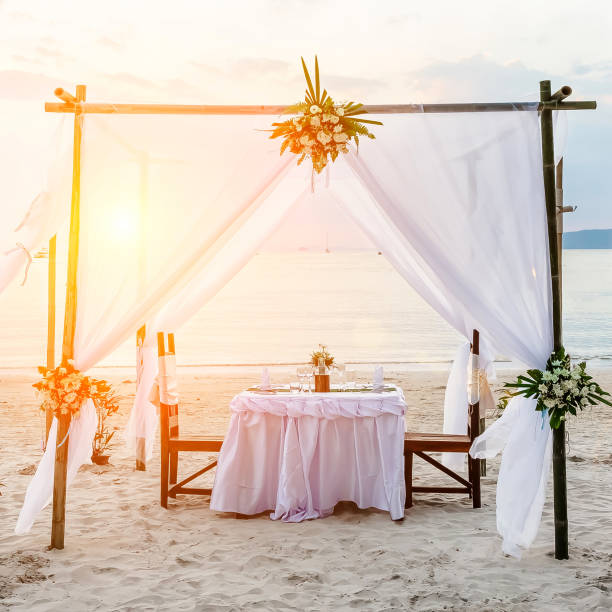 istock Square image. Sunset and romantic luxury dinner at tropical beach. Decorated table with vine glasses. 1157191257