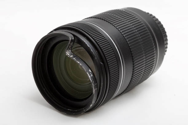istock Damaged and broken zoom lens for the digital camera, dented protective UV filter. Front side closeup view. To be repaired. Isolated on white background 1157191305