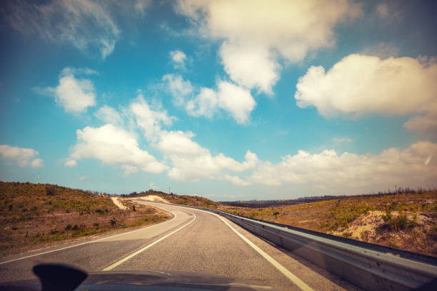 conduire une voiture sur une route sinueuse de montagne au portugal un jour ensoleillé avec un ciel nuageux - car street horizon over land sky photos et images de collection