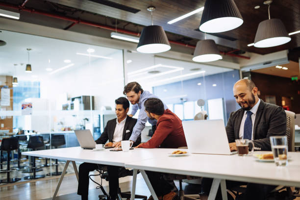istock Business people in Latin start-up company working together and using laptops. 1157200662