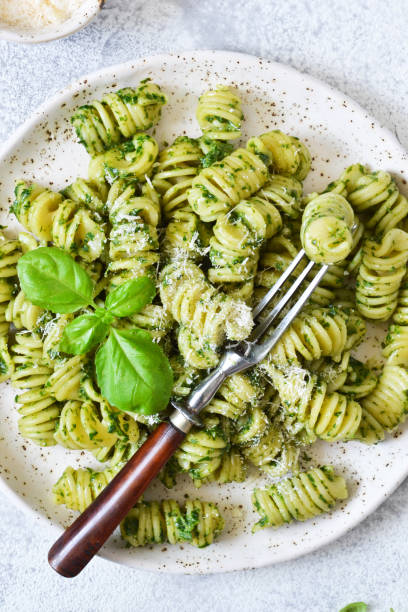 istock Vegan pasta with spinach, basil and parmesan. Lunch on the kitchen table. 1157201793