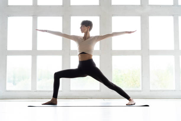 istock Young yogi woman practicing yoga, standing in Warrior two exercise, Virabhadrasana II pose, working out wearing sportswear. Weight loss concept. 1157204353