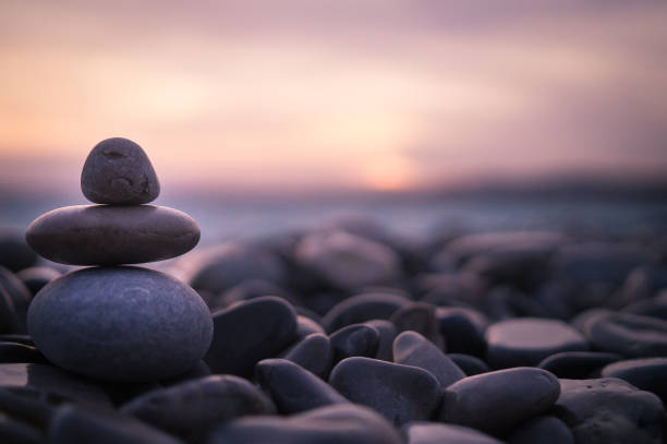 sonnenuntergang mit kieselsteinen am strand in nizza, frankreich. - fels stock-fotos und bilder