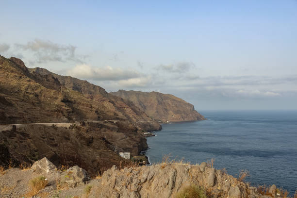 istock Steep high lava rock cliffs. Blue sea horizon, natural sky background. 1157209345