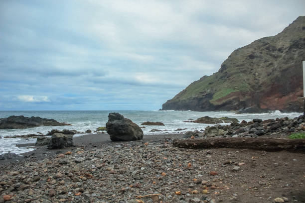istock Steep high lava rock cliffs. Blue sea horizon, natural sky background. 1157210310