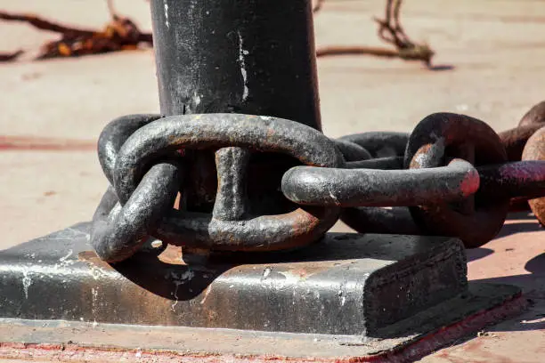 Photo of A huge chain tied to an iron heavy pole to hold ships steady near port