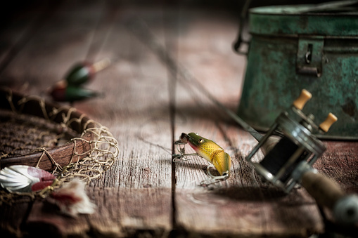 Vintage fishing lure/tackle, bobbers and floats with net on an old wood background