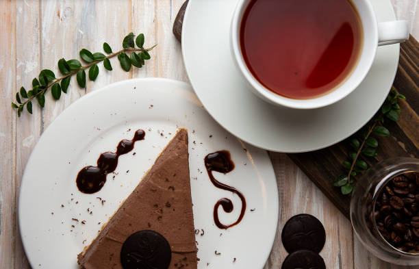 istock Chocolate mousse cheesecake with chocolate chips and a cup of tea in white cup. 1157216643