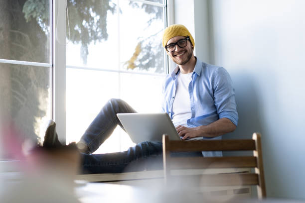 istock Young businessman working on modern loft office. Man sitting by the window, using contemporary notebook. 1157219382