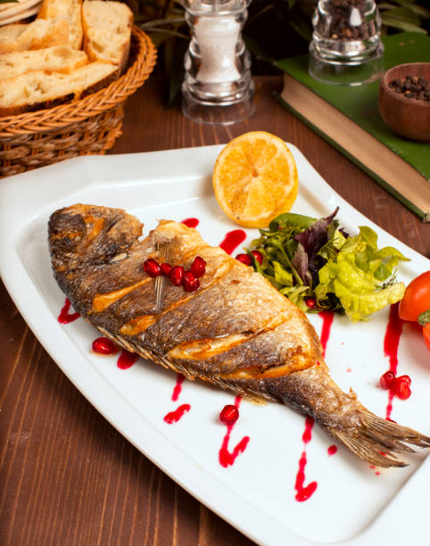 Grilled whole fish with yellow sauce.