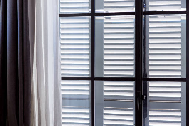 istock a window with closed shutters and open curtains of white textiles. 1157221527
