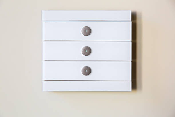 istock A modern white glass touch sensitive multifunctional light switch with indicators instal on a beige wall close up. 1157221588