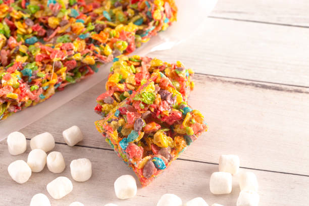 Fruity Cereal Marshmallow Treat Bars on a Light Wood Table