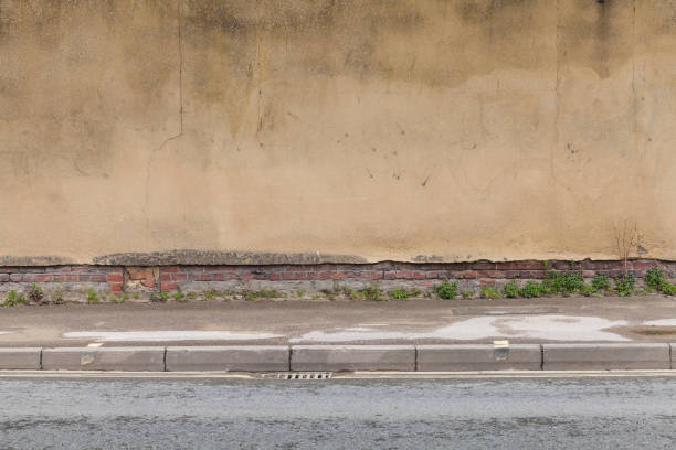 istock Old brick wall with damaged yellow stucco 1157227337