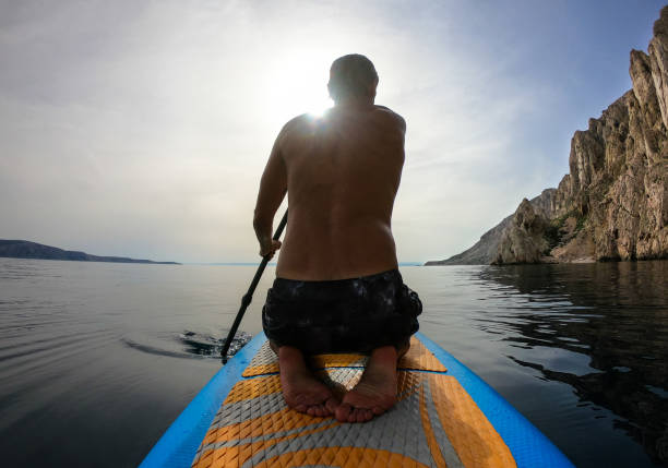 istock Man paddling towards the sun 1157227524