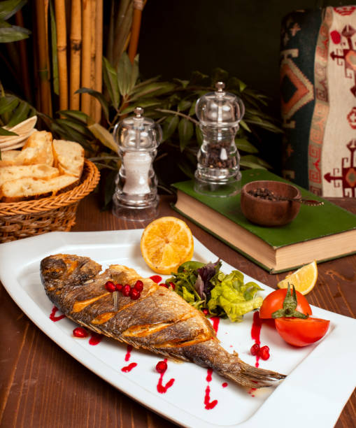 Grilled whole fish with yellow sauce.