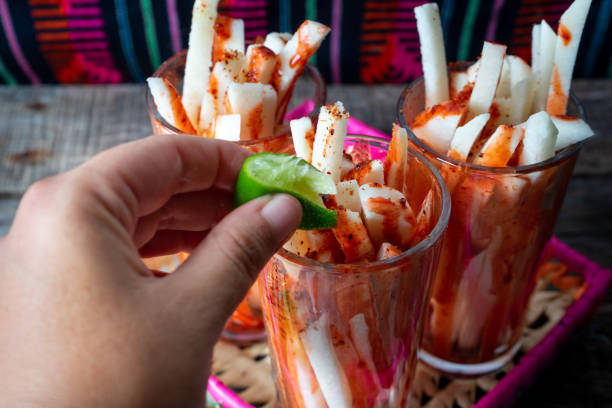 Mexican jicama fruit cutted with lime, chili powder and chamoy Mexican jicama fruit cutted with green lime, chili powder and chamoy pachyrhizus erosus stock pictures, royalty-free photos & images