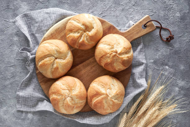 istock Crusty round bread rolls, known as Kaiser or Vienna rolls on linen towel 1157231424