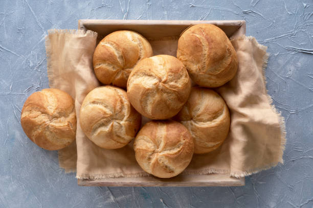 istock Crusty round bread rolls, known as Kaiser or Vienna rolls on linen towel 1157232291