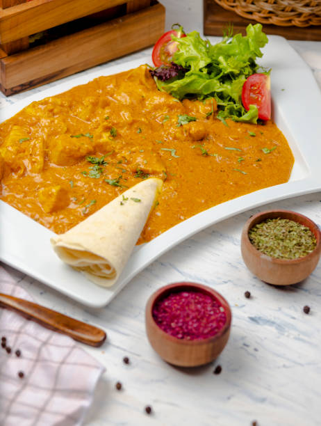 istock Indian curry with chicken breast and tomato sauce served with lavash. 1157234246