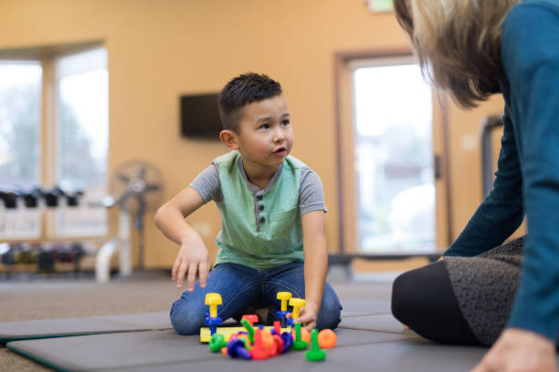 istock Occupational therapist works with a young ethnic boy 1157244303